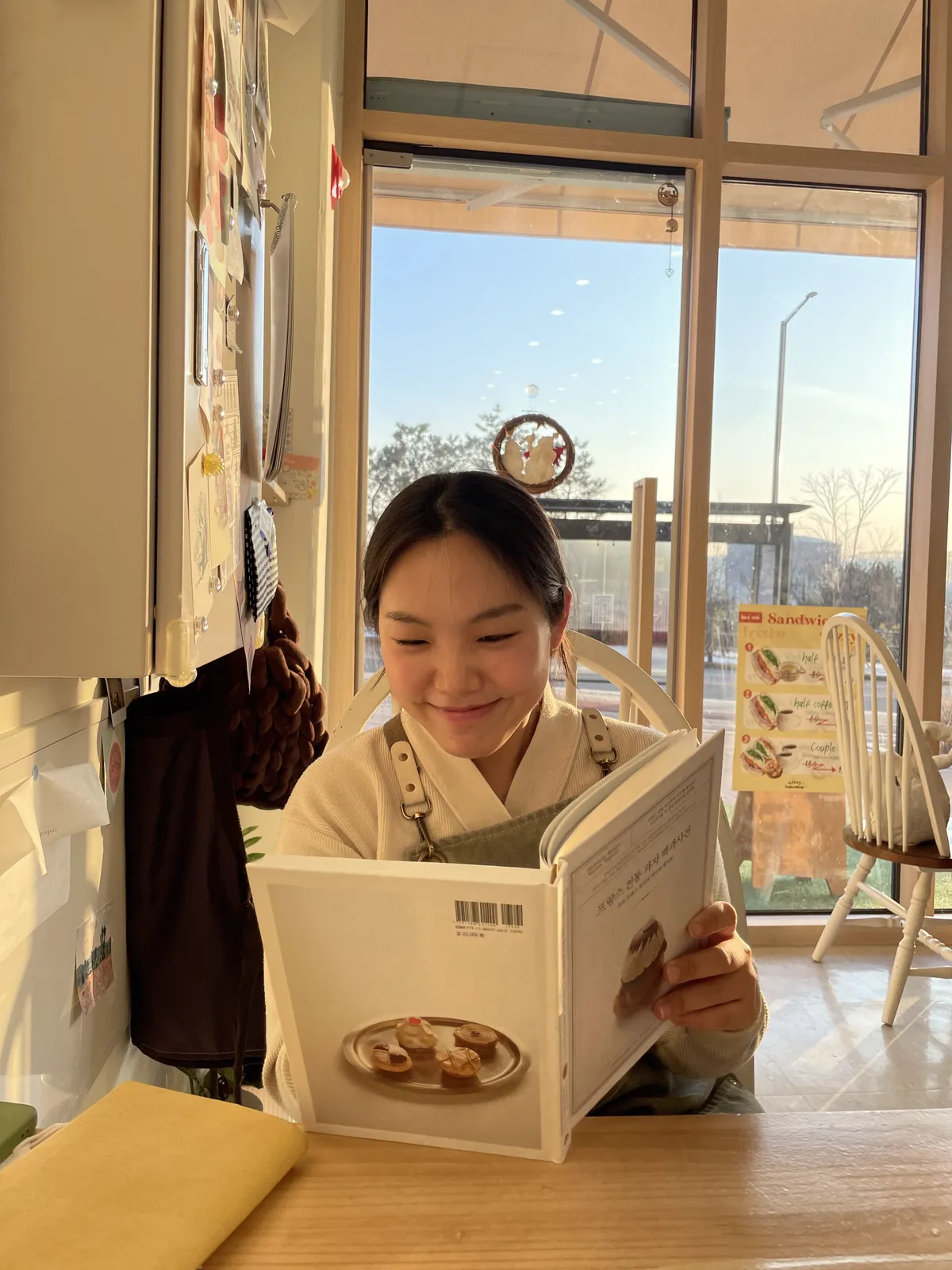 저녁 빛이 드는 매장에서 제과 서적을 보고 있는 모습